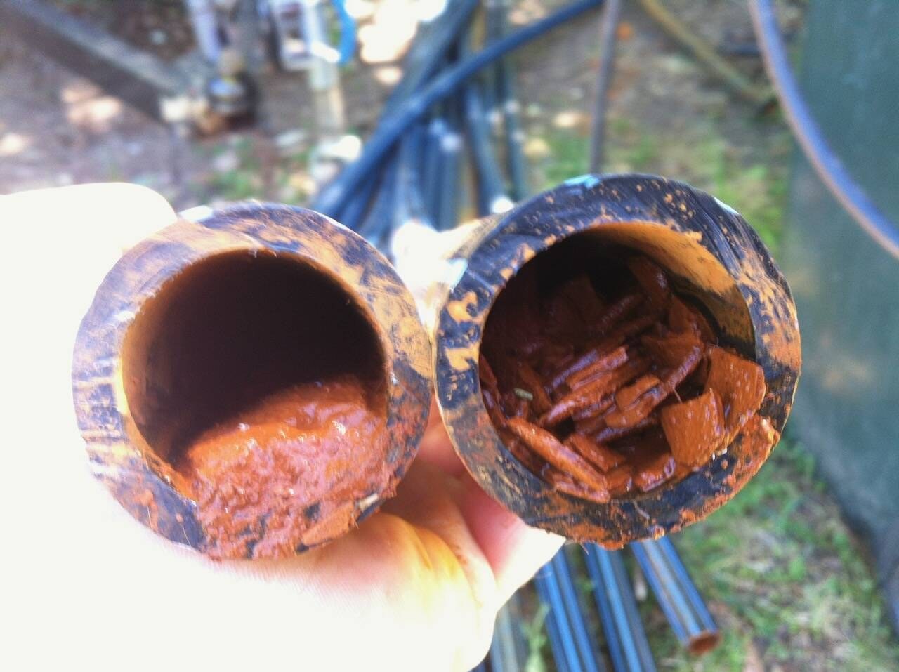 Two pipe sections choked with iron build-up