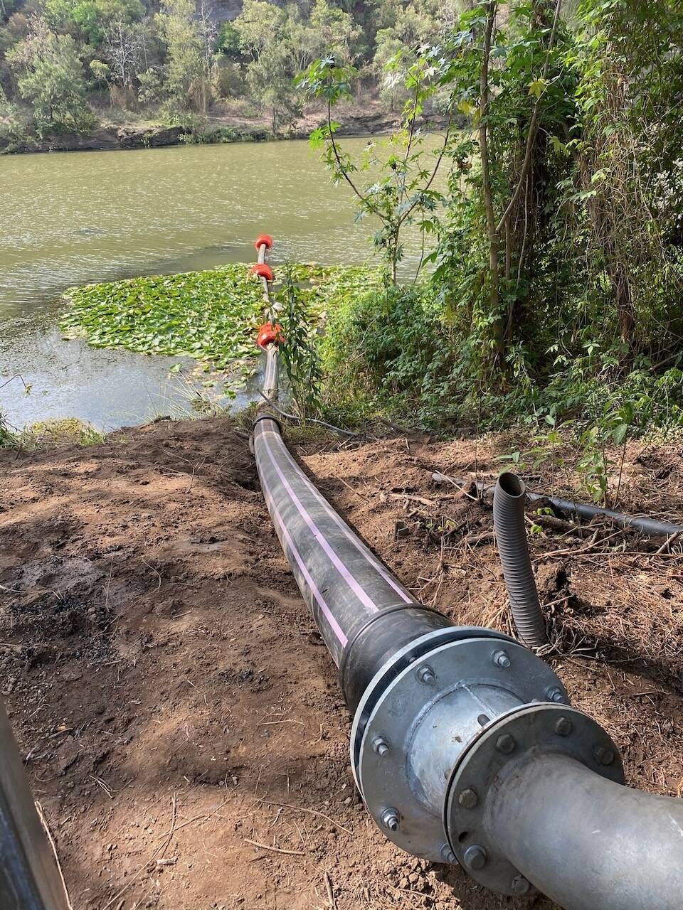 A large flanged mainline running up from a lagoon