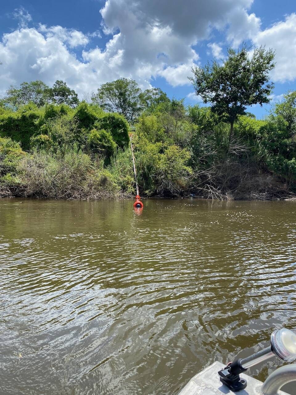 An orange float marking a pump intake on the river