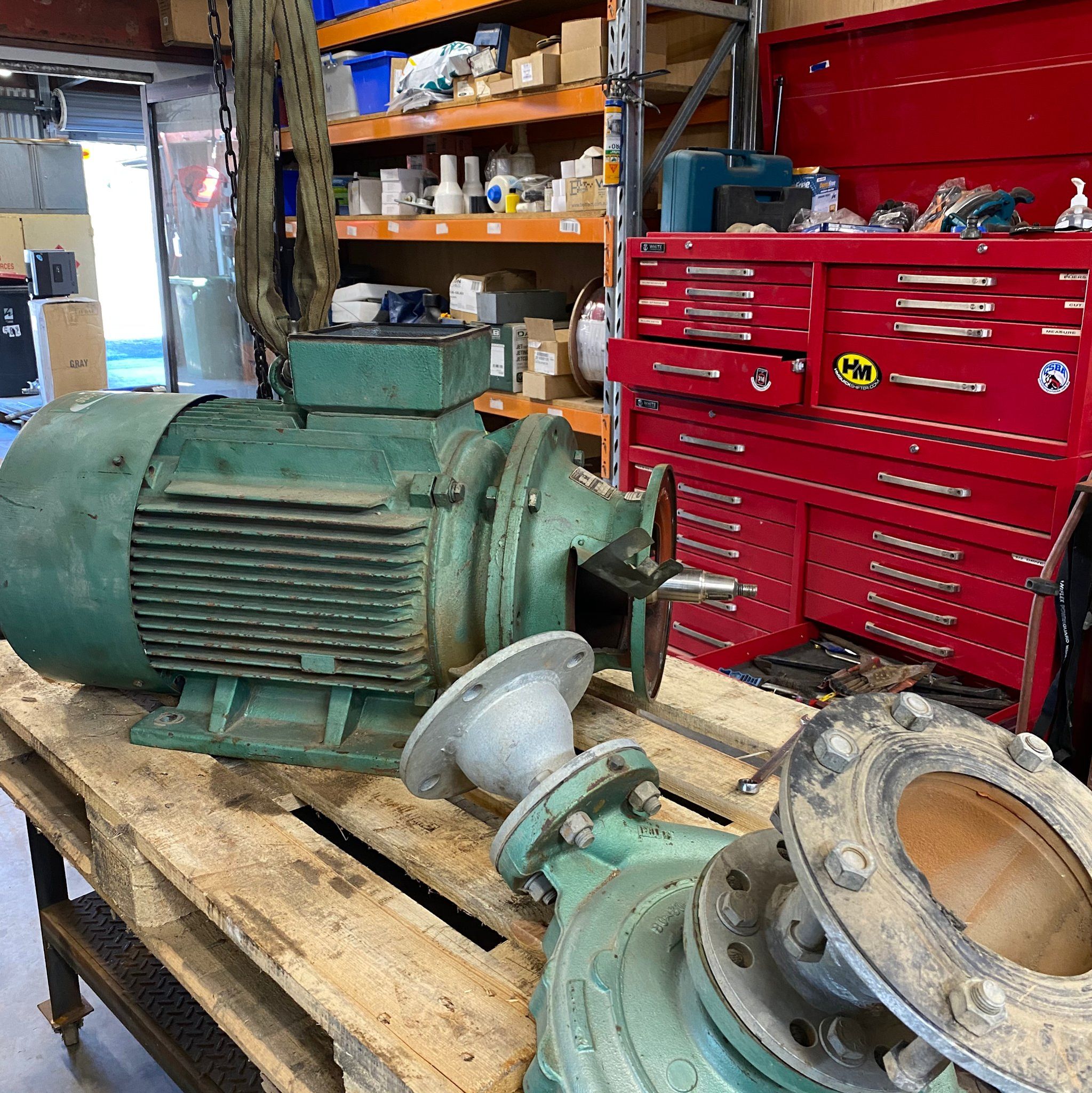 A large electric motor and pump end on the bench in the Freemans Reach workshop